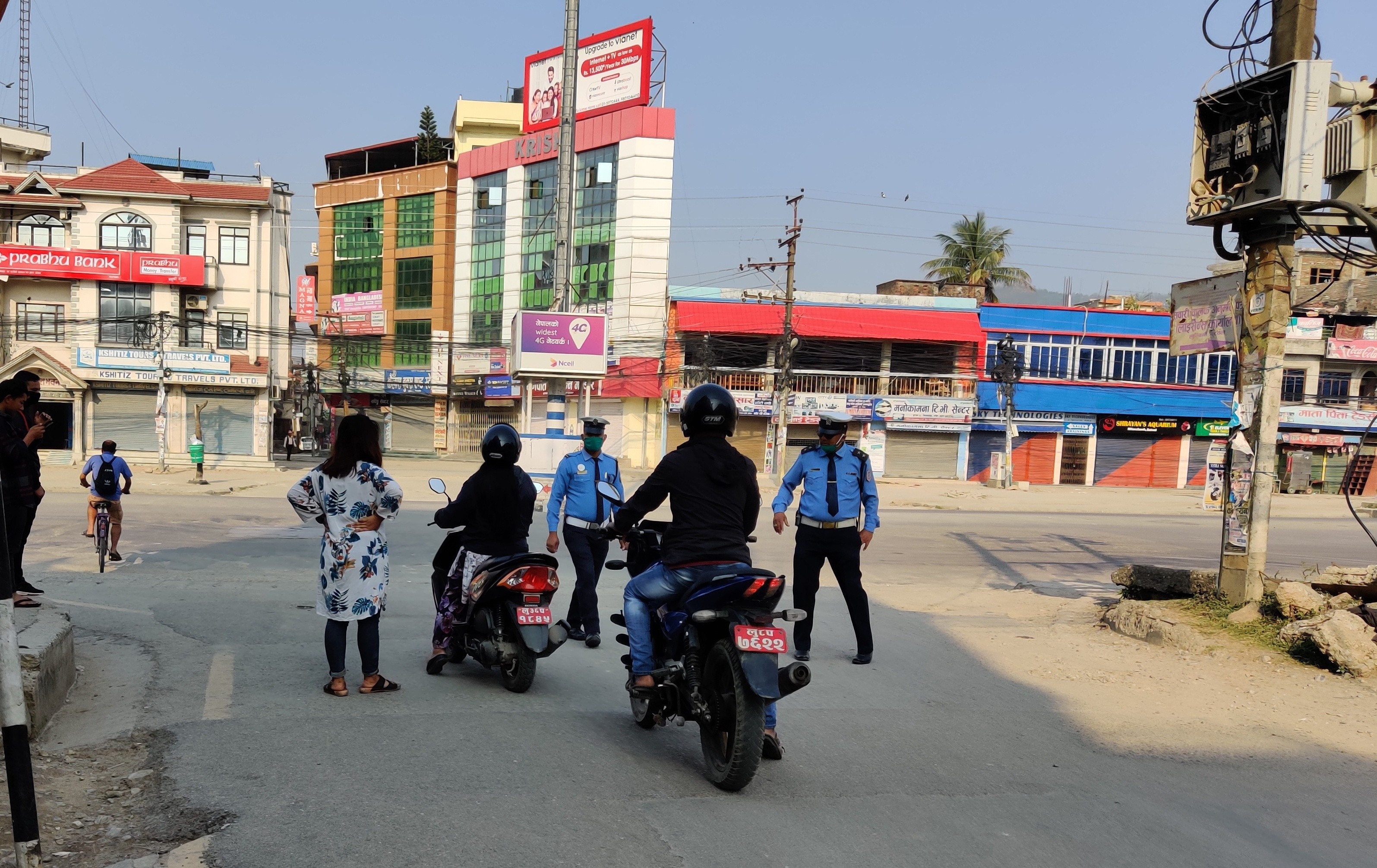 बुटवलको मिलनचोकमा लकडाउन उल्लंघन गर्नेहरूलाई रोक्दै सुरक्षाकर्मी ।